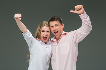 Image showing Portrait of a young couple standing against gray background