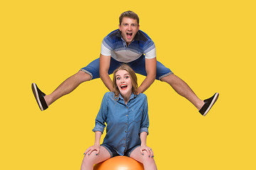 Image showing Portrait of a young couple jumping against yellow background