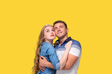 Image showing Portrait of a young couple standing against yellow background