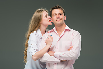 Image showing Portrait of a young couple standing against gray background