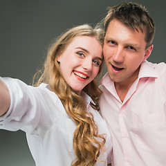 Image showing Portrait of a young couple standing against gray background