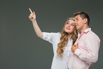 Image showing Portrait of a young couple standing against gray background