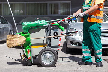 Image showing Worker of cleaning company in green uniform with garbage bin.