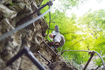 Image showing Woman climbing on the rocky route up the mountain.