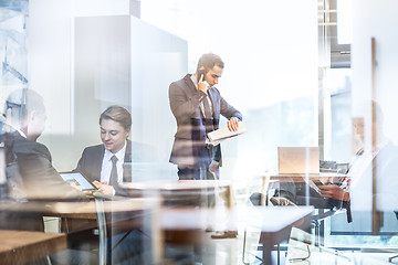 Image showing Businessman talking on a mobile phone on corporate office.