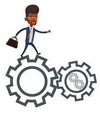 Image showing Business man running on cogwheels.