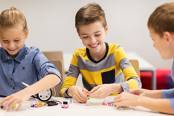 Image showing happy children building robots at robotics school