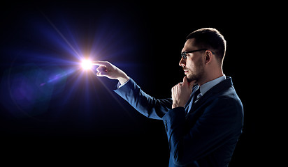 Image showing businessman in suit with light over black