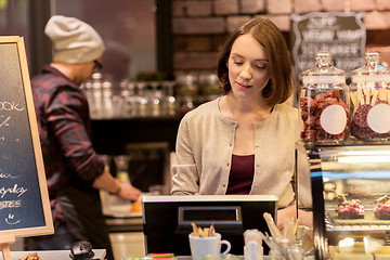 Image showing woman bartender at cafe or coffee shop cashbox