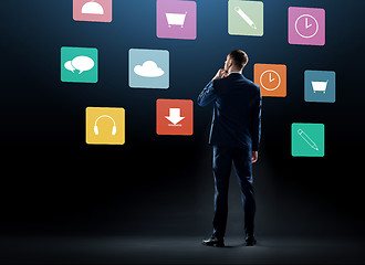 Image showing businessman in suit looking at virtual menu icons