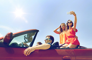 Image showing friends driving in cabriolet car and taking selfie