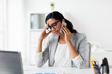 Image showing stressed businesswoman with smartphone at office