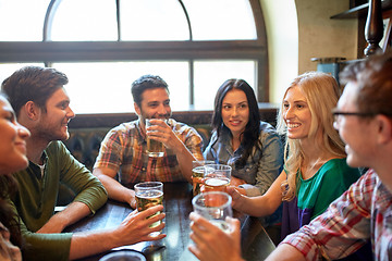 Image showing happy friends drinking beer at bar or pub