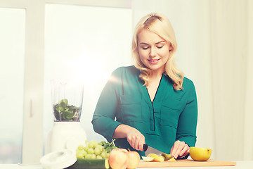 Image showing smiling woman with blender cooking food at home