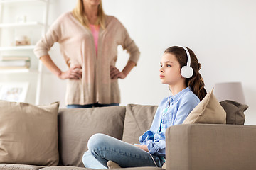 Image showing girl with earphones and angry mother at home