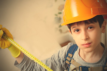 Image showing boy in a protective helmet with a measuring tape