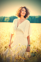 Image showing Beautiful woman dressed in a white dress among the ears in the f