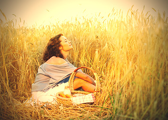 Image showing Beautiful woman relaxes in a field among wheat ears