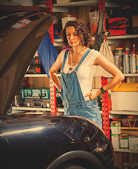 Image showing pretty woman mechanic prepares the car for the travel