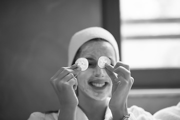 Image showing woman is getting facial clay mask at spa