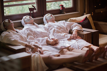 Image showing women is getting facial clay mask at spa