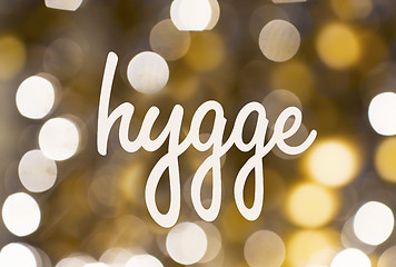 Image showing word hygge over blurred golden lights background