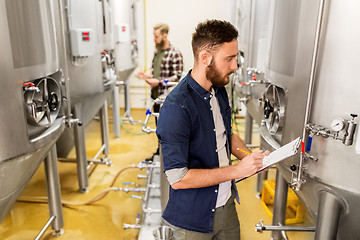 Image showing men with clipboard at craft brewery or beer plant