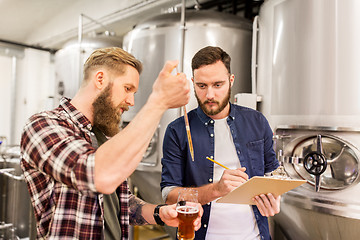 Image showing men with pipette testing craft beer at brewery