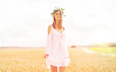 Image showing happy young woman in flower wreath on cereal field