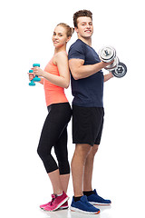 Image showing sportive man and woman with dumbbells