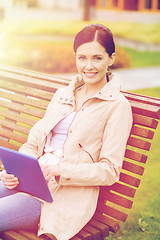 Image showing woman with tablet pc sitting on bench in park
