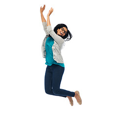 Image showing smiling young indian woman jumping in air