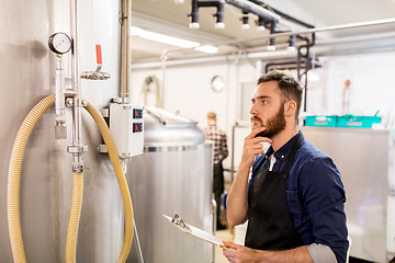 Image showing man with clipboard at craft brewery or beer plant