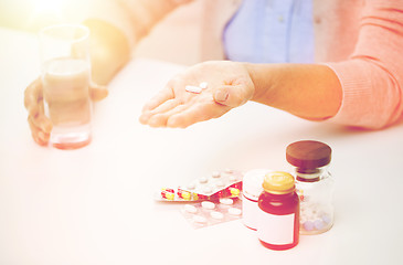 Image showing close up of senior woman with pills and water 