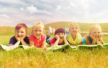 Image showing group of kids lying on blanket or cover outdoors