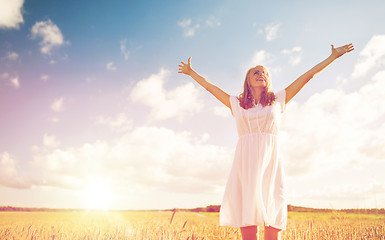 Image showing smiling young woman in white dress on cereal field