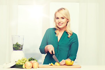 Image showing smiling woman with blender cooking food at home