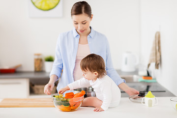 Image showing happy mother and baby with food at home kitchen