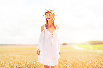 Image showing happy young woman in flower wreath on cereal field