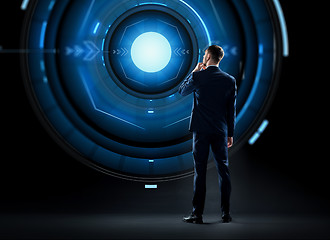 Image showing businessman in suit looking at virtual projection