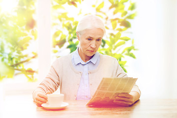 Image showing senior woman with coffee reading newspaper