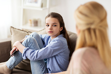 Image showing sad girl with mother sitting on sofa at home