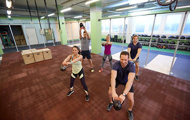 Image showing group of people with kettlebells exercising in gym