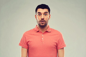 Image showing surprised man in polo t-shirt over gray background