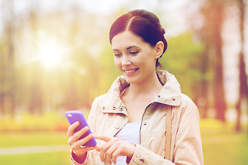 Image showing smiling woman calling on smartphone in park