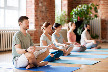 Image showing group of people making yoga exercises at studio