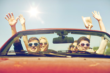 Image showing happy friends driving in cabriolet car at country