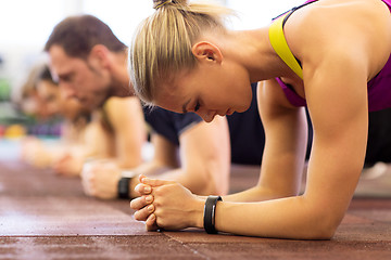 Image showing close up of woman at training doing plank in gym