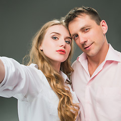 Image showing Portrait of a young couple standing against gray background
