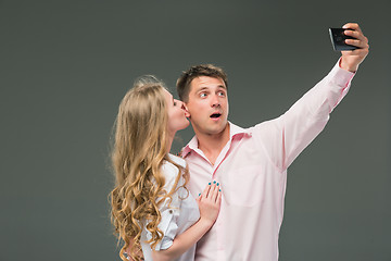 Image showing Portrait of a young couple standing against gray background